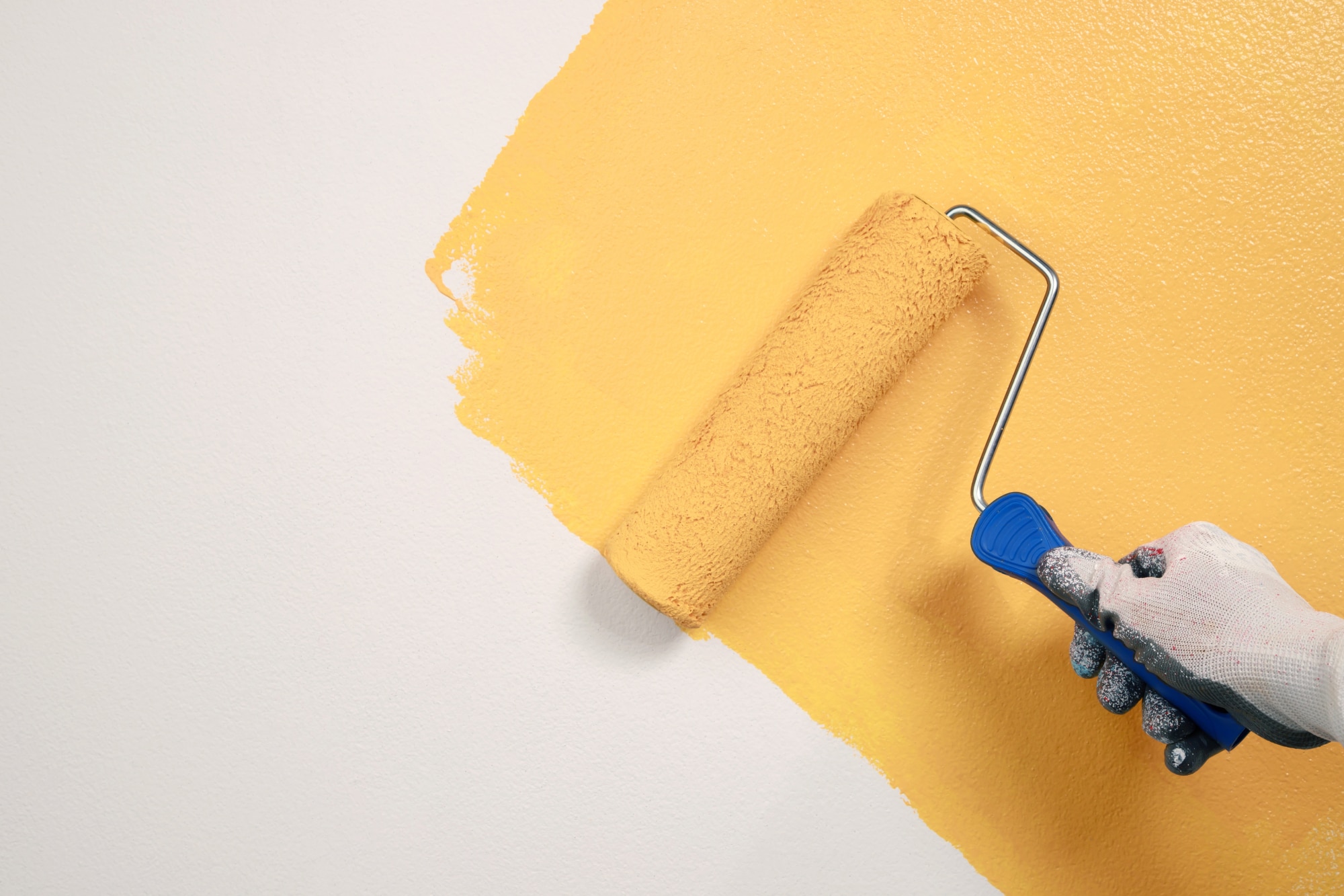 Roller Brush Painting, Worker painting on surface wall  Painting apartment, renovating with yellow color  paint. Leave empty copy space white to write descriptive text beside